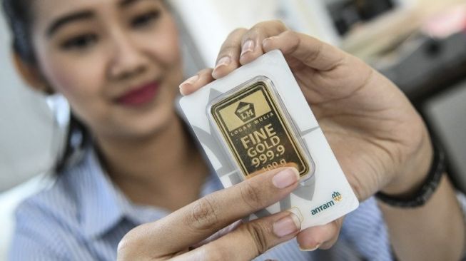 Seorang petugas menunjukkan emas batangan besutan Aneka Tambang. FOTO - ISTIMEWA Meroket 826 Persen, Laba ANTM Kuartal I-2025 Tembus Rp2,13 Triliun
