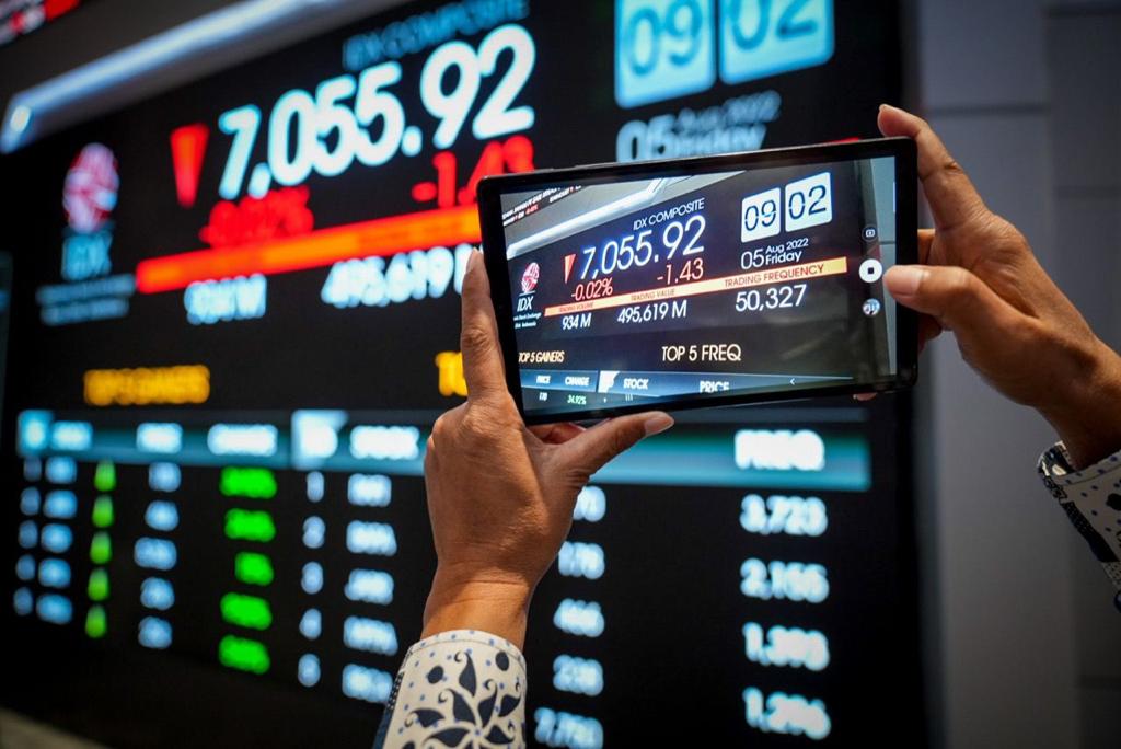 Seseorang tampak mengabadikan pergerakan IHSG via ponsel pintar. FOTO - ISTIMEWA Mengekor Wall Street, Koreksi Bayangi IHSG