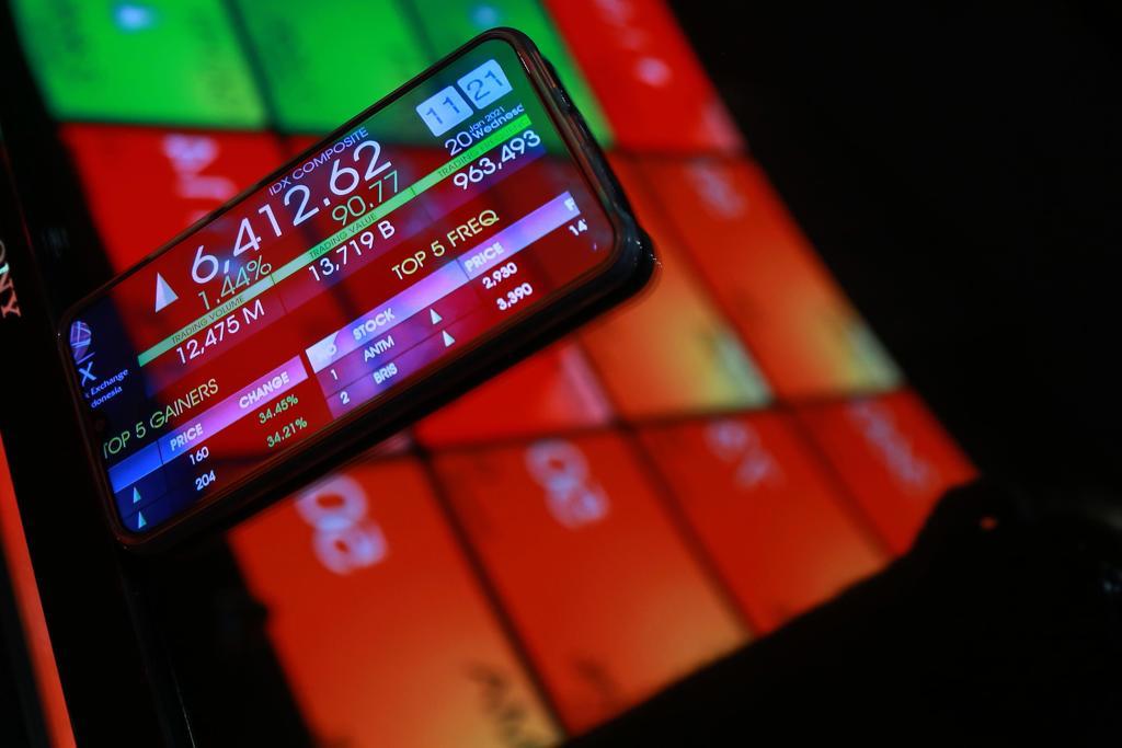 Tampak seseorang mengamati pergerakan IHSG melalui ponsel pintar. FOTO - ISTIMEWA Masih Tertekan, IHSG Menuju Level 6.850